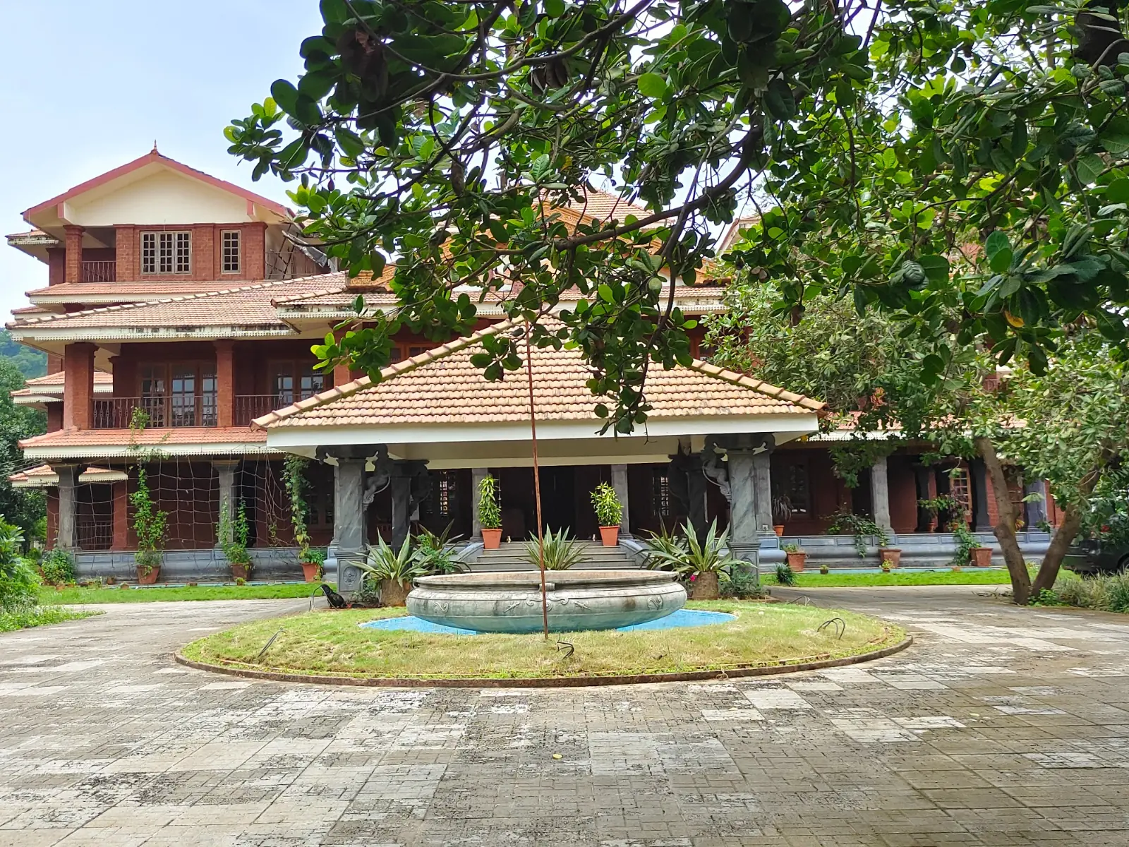 Tiled-roof entrance and stone fountain in front of an Ayurveda centre near Panvel, Maharashtra