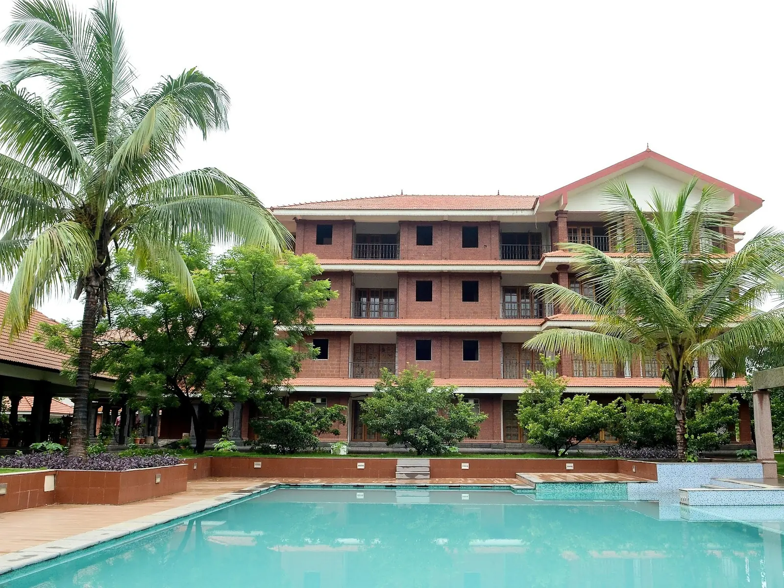 Kerala-style laterite building around a courtyard lawn at an Ayurveda centre near Panvel, Maharashtra