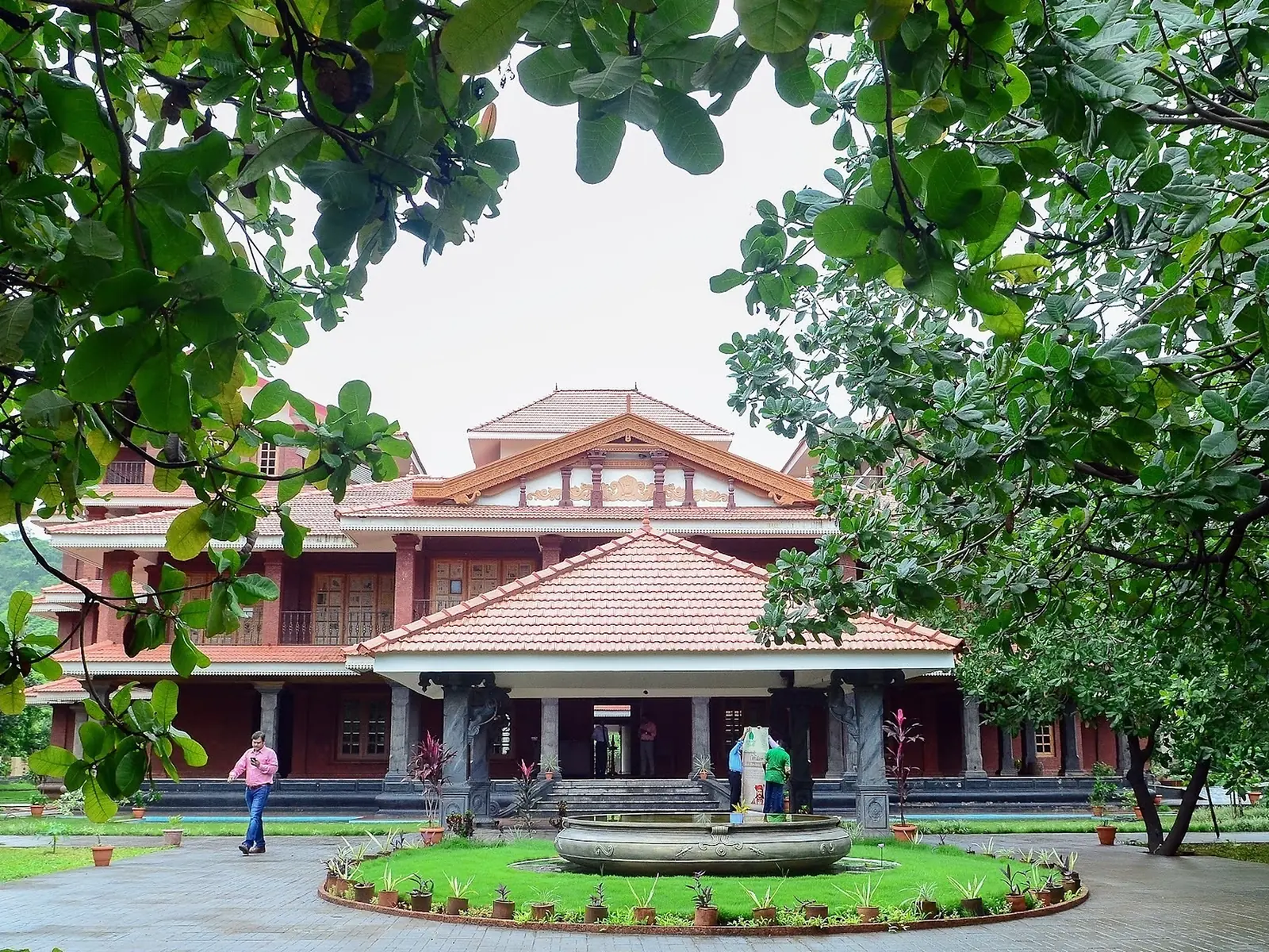 Kerala-style laterite building around a courtyard lawn at an Ayurveda centre near Panvel, Maharashtra