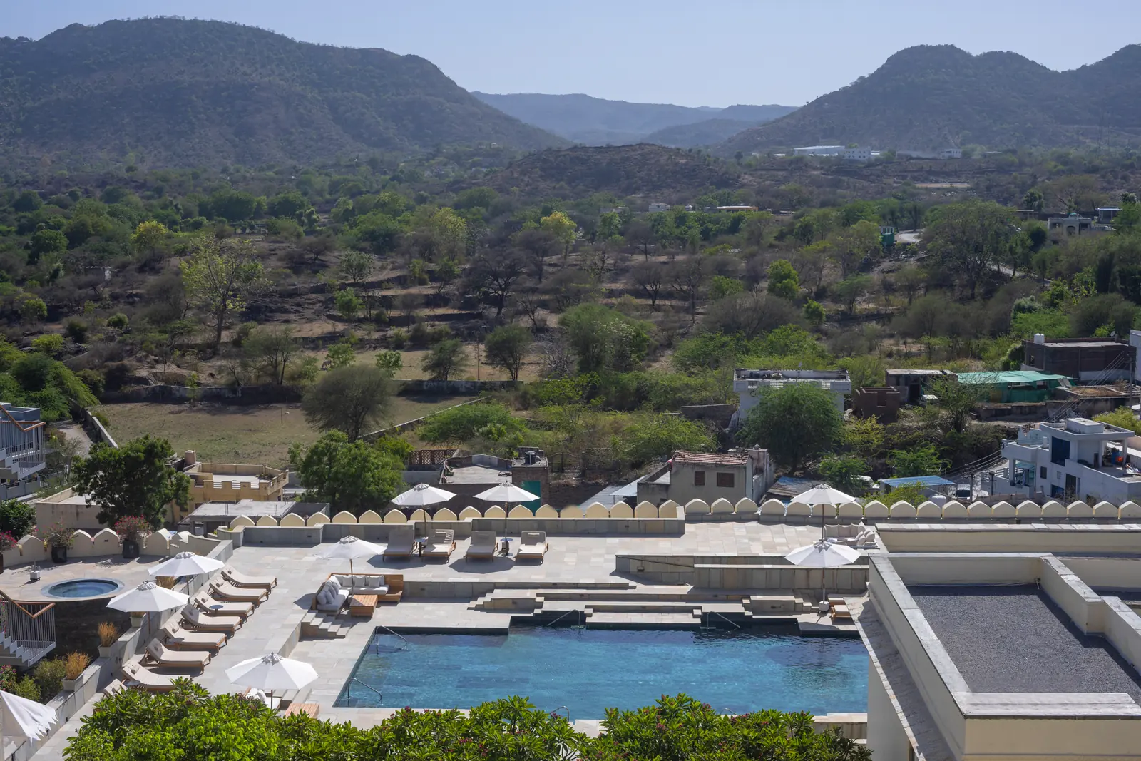 Restored hilltop fort palace above its gardens at sunset in the Aravalli hills near Udaipur