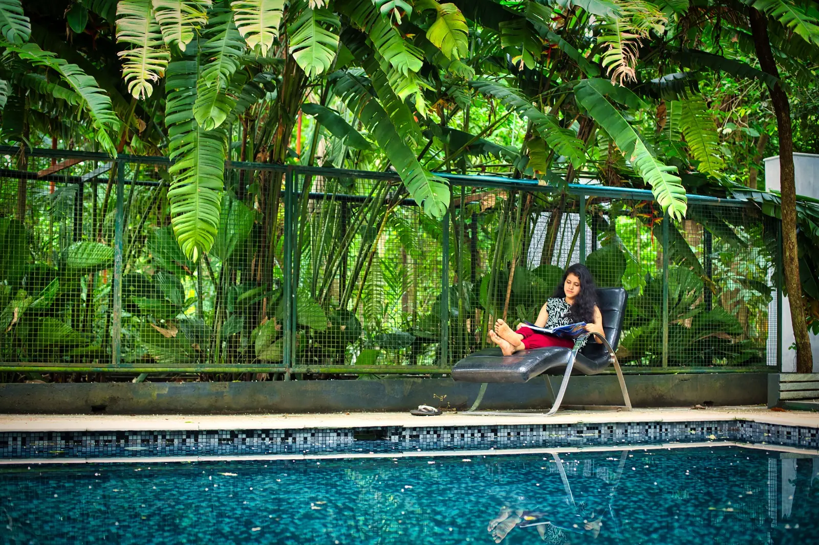 Guests meditating on an open-air yoga deck surrounded by forest at an Ayurveda retreat in Kerala