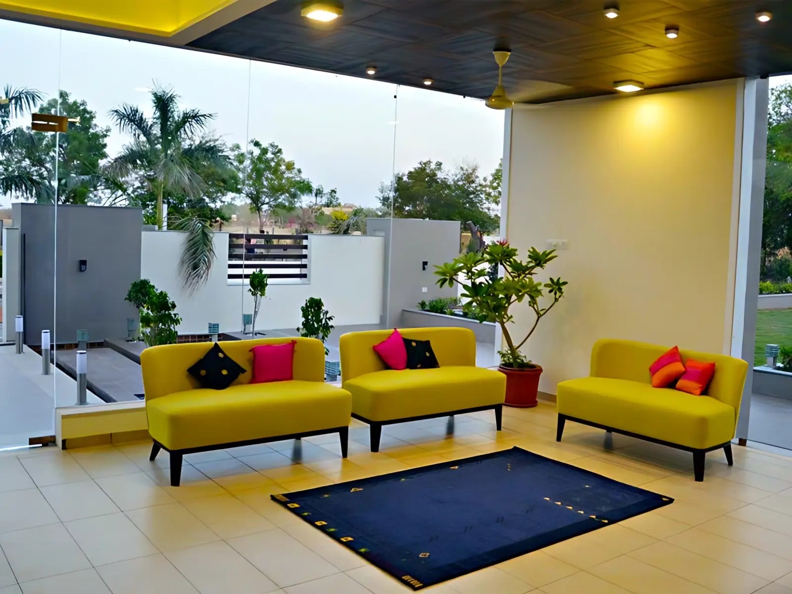 Curved brick path through a garden with palms to a pavilion at a Naturopathy centre in Gujarat